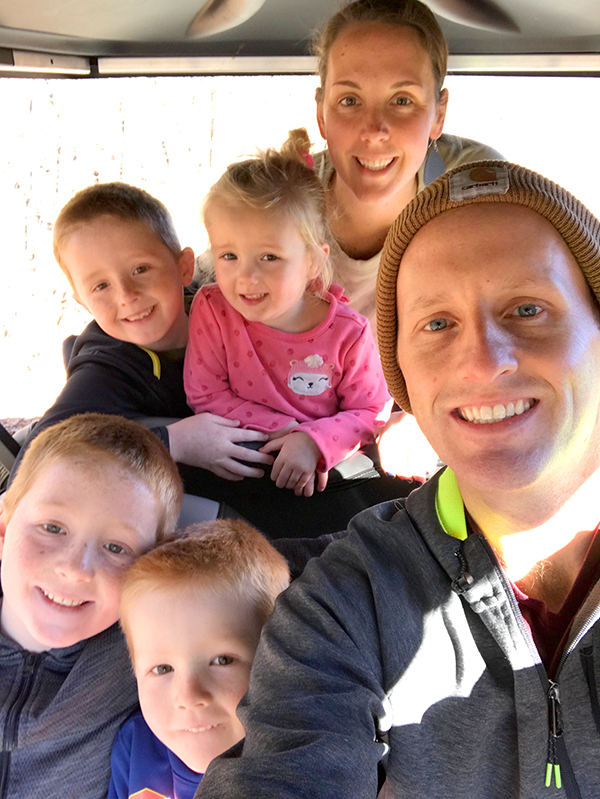 Picture of the Jesse and Kirsten Lancour and their four kids smiling for a photo.