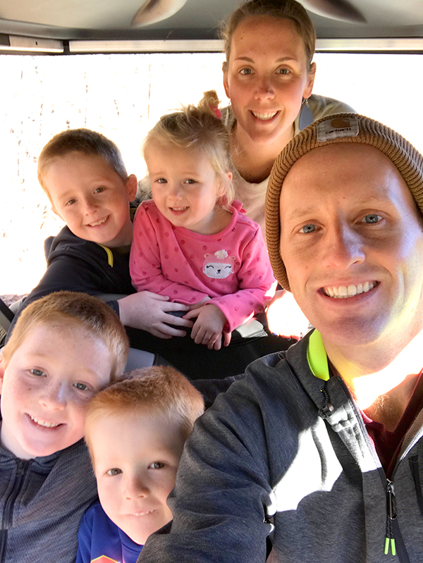 Picture of the Jesse and Kirsten Lancour and their four kids smiling for a photo.
